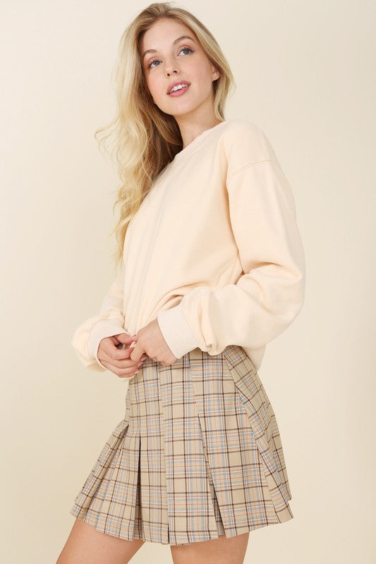 Tailored beige plaid mini skirt with pleats and six pin-tucks on both the front and back. Side zipper with a high waist.