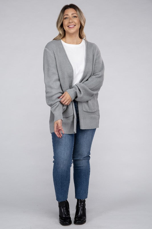 Curvy plus-size waffle-pattern open cardigan sweater in light grey, with long sleeves, oversized fit, and pockets.