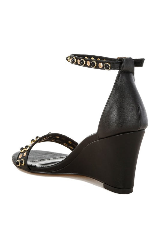 Black studded ankle strap wedge sandals back angle view.