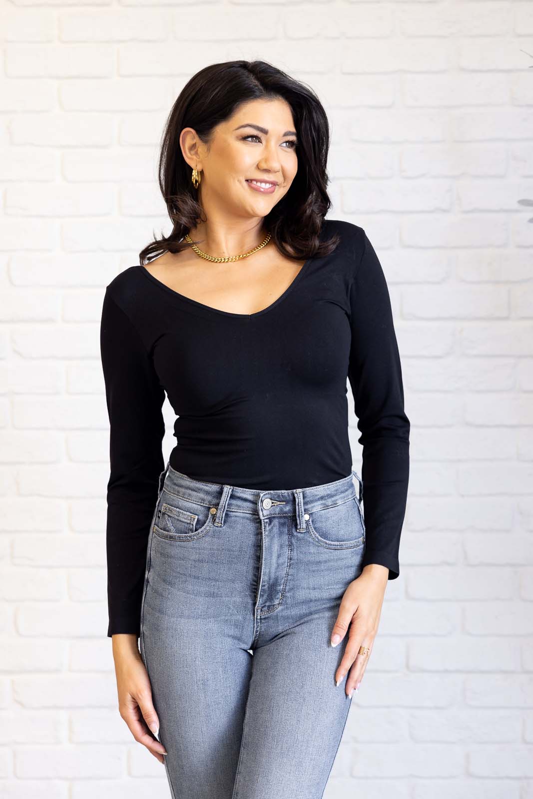 Black long-sleeve reversible top with a scoop and V-neckline, made from soft brushed microfiber in a form-fitting silhouette.