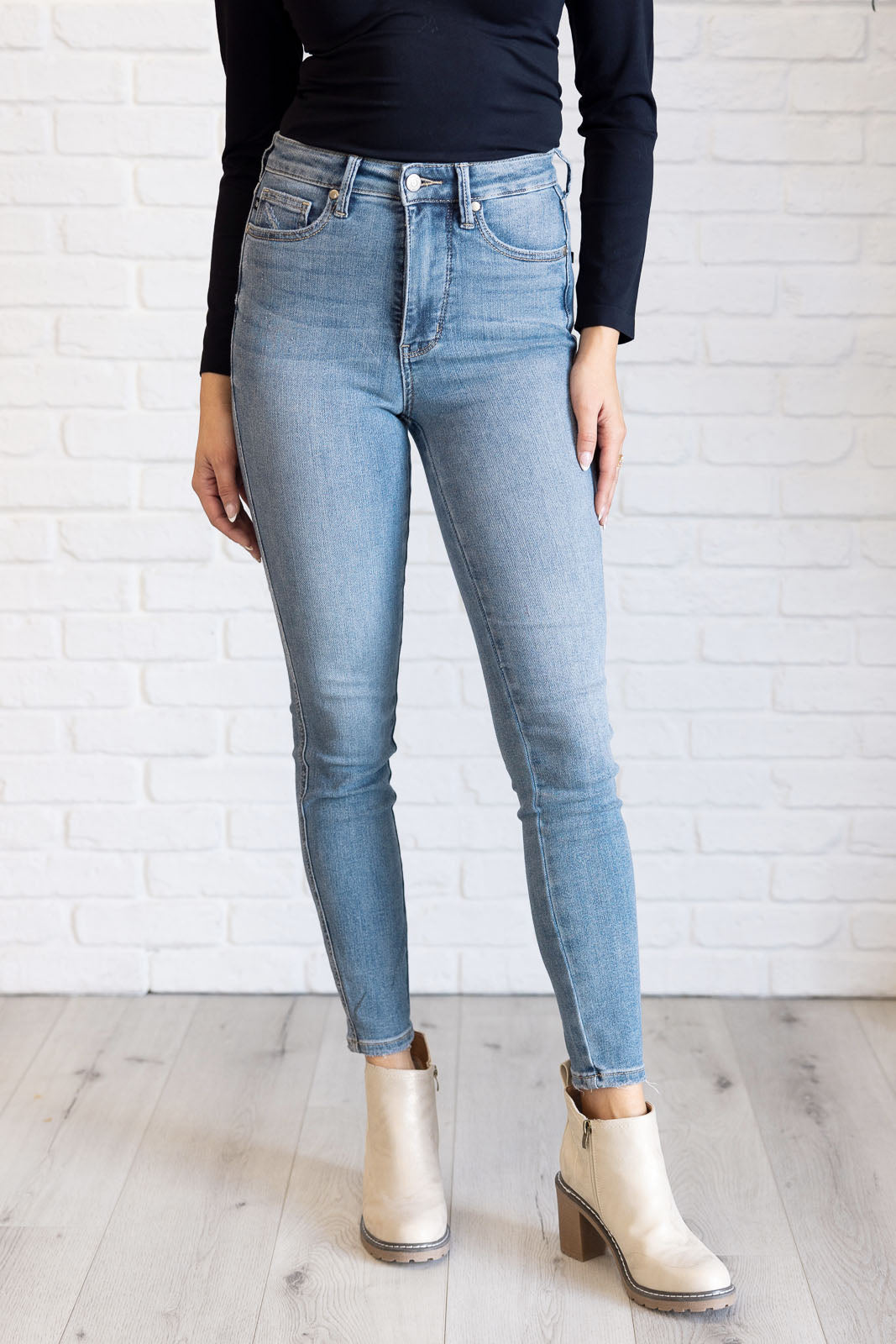 Justine High Rise Skinny Jeans by Judy Blue in a light contrast wash, featuring a zip fly, tummy control panel, and high-rise waist for a flattering fit.