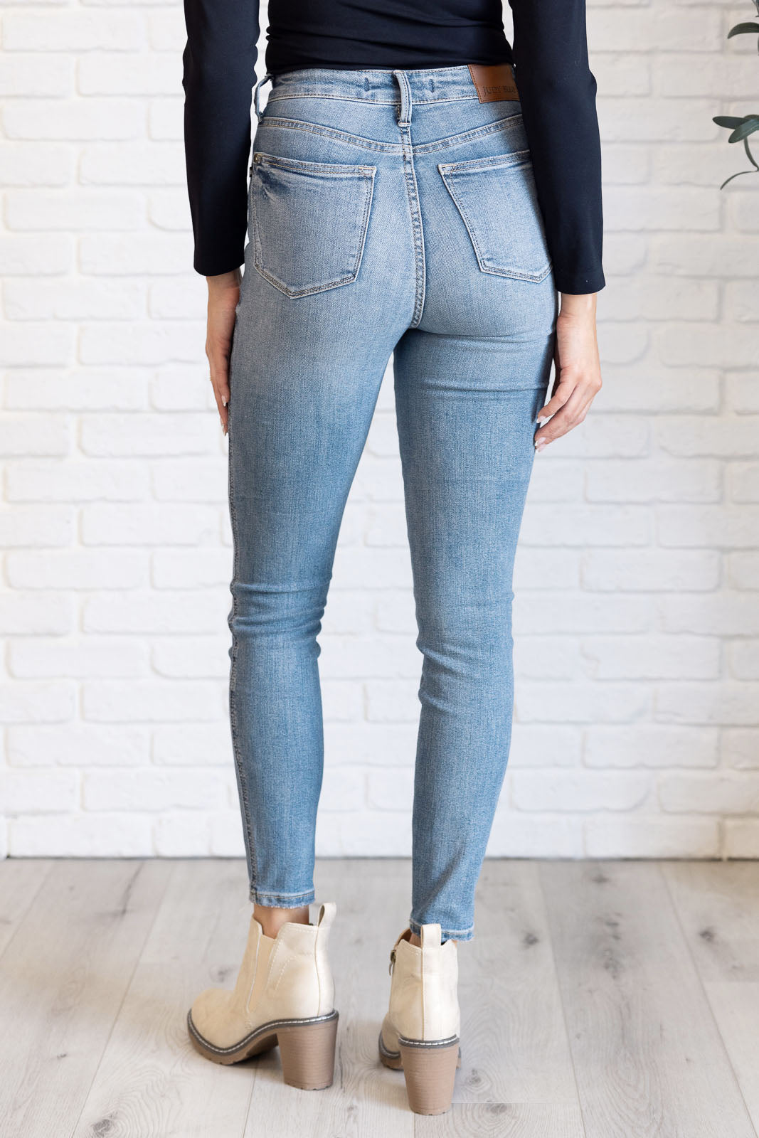 Back View of Justine High Rise Skinny Jeans by Judy Blue in a light contrast wash, featuring a zip fly, tummy control panel, and high-rise waist for a flattering fit.