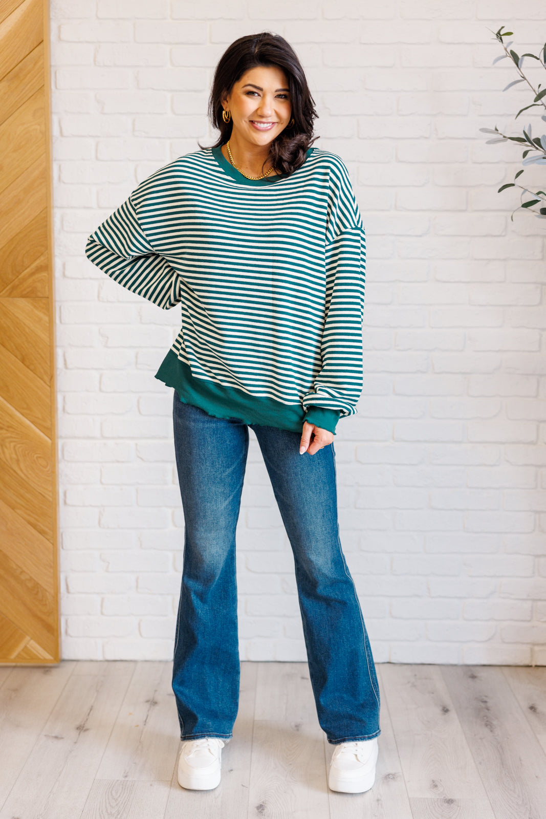 Women's green striped drop shoulder top with long sleeves, banded ribbed neckline, cuffs, and hemline, made of midweight knit fabric.