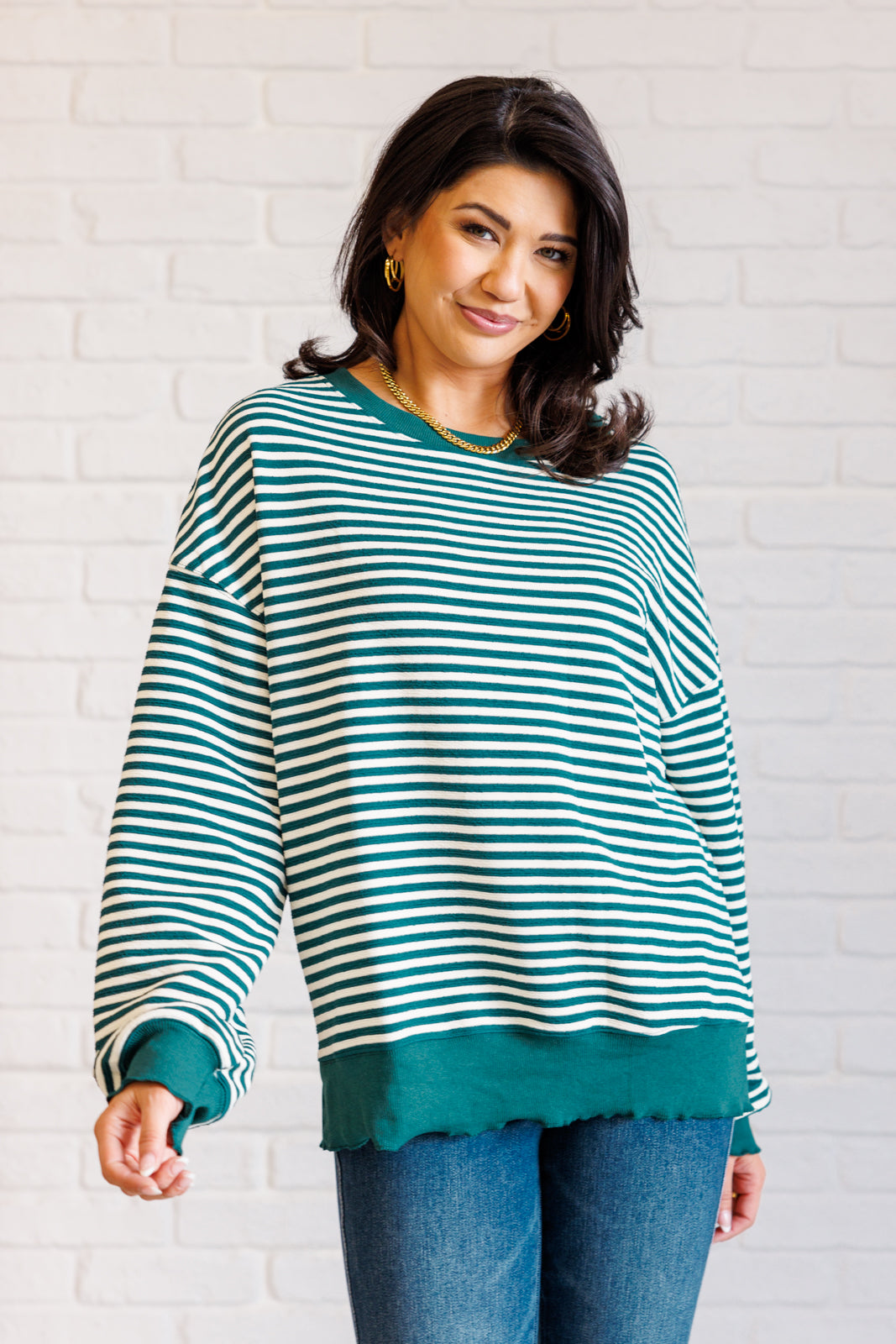 Women's green striped drop shoulder top with long sleeves, banded ribbed neckline, cuffs, and hemline, made of midweight knit fabric.