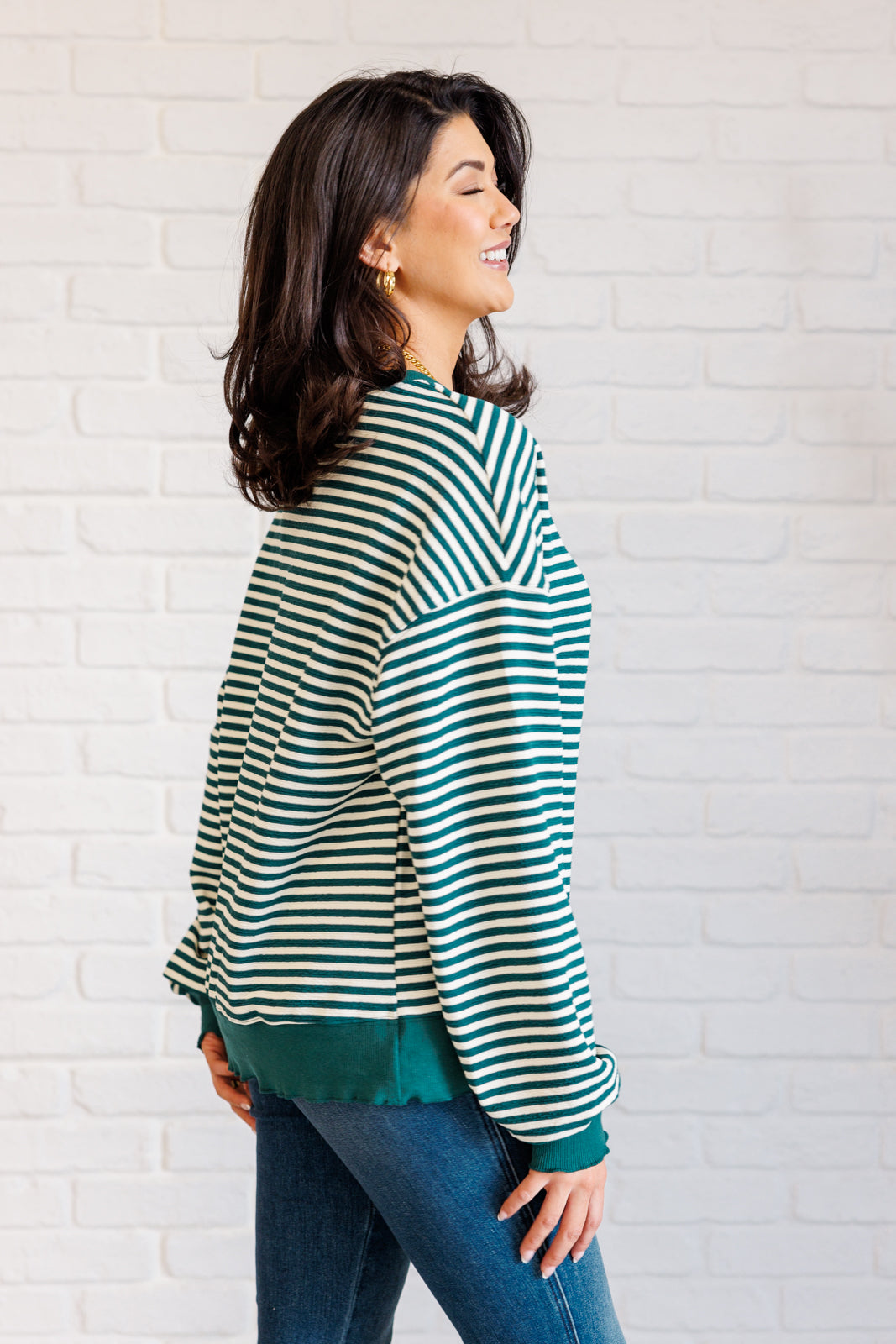 Women's green striped drop shoulder top with long sleeves, banded ribbed neckline, cuffs, and hemline, made of midweight knit fabric.