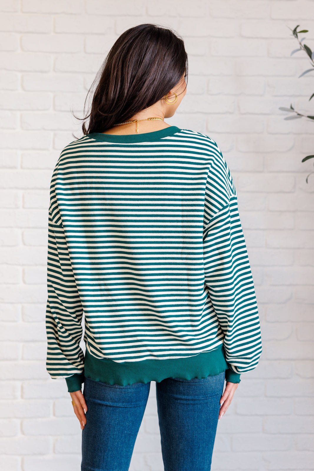 Women's green striped drop shoulder top with long sleeves, banded ribbed neckline, cuffs, and hemline, made of midweight knit fabric.