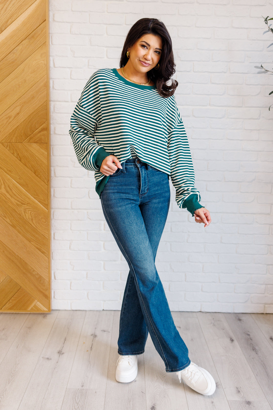 Women's green striped drop shoulder top with long sleeves, banded ribbed neckline, cuffs, and hemline, made of midweight knit fabric.