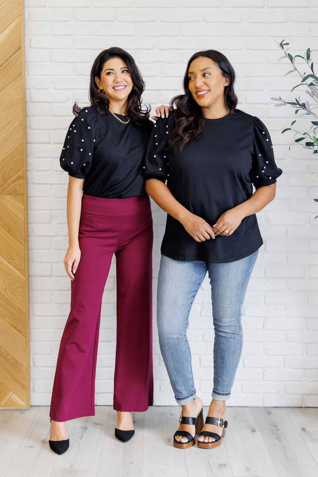 Black French terry top with a ribbed neckline, short balloon sleeves embellished with pearl and faux diamond accents, and ribbed sleeve cuffs.