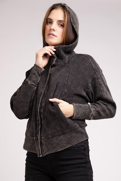 Model wearing Ash Black Hanna Jacket with hood up, showing slouchy hood detail.
