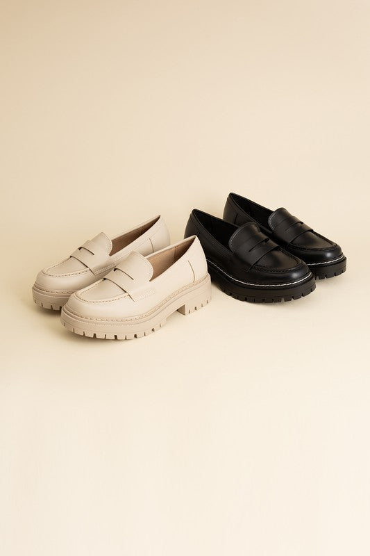 Black and Bone colored classic loafers with a sleek design and minimalist accents.