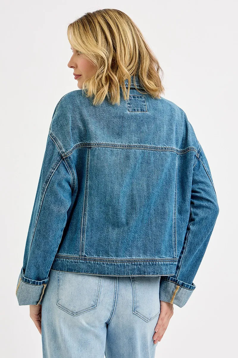 Back view of oversized denim jacket with relaxed fit and structured shoulders.