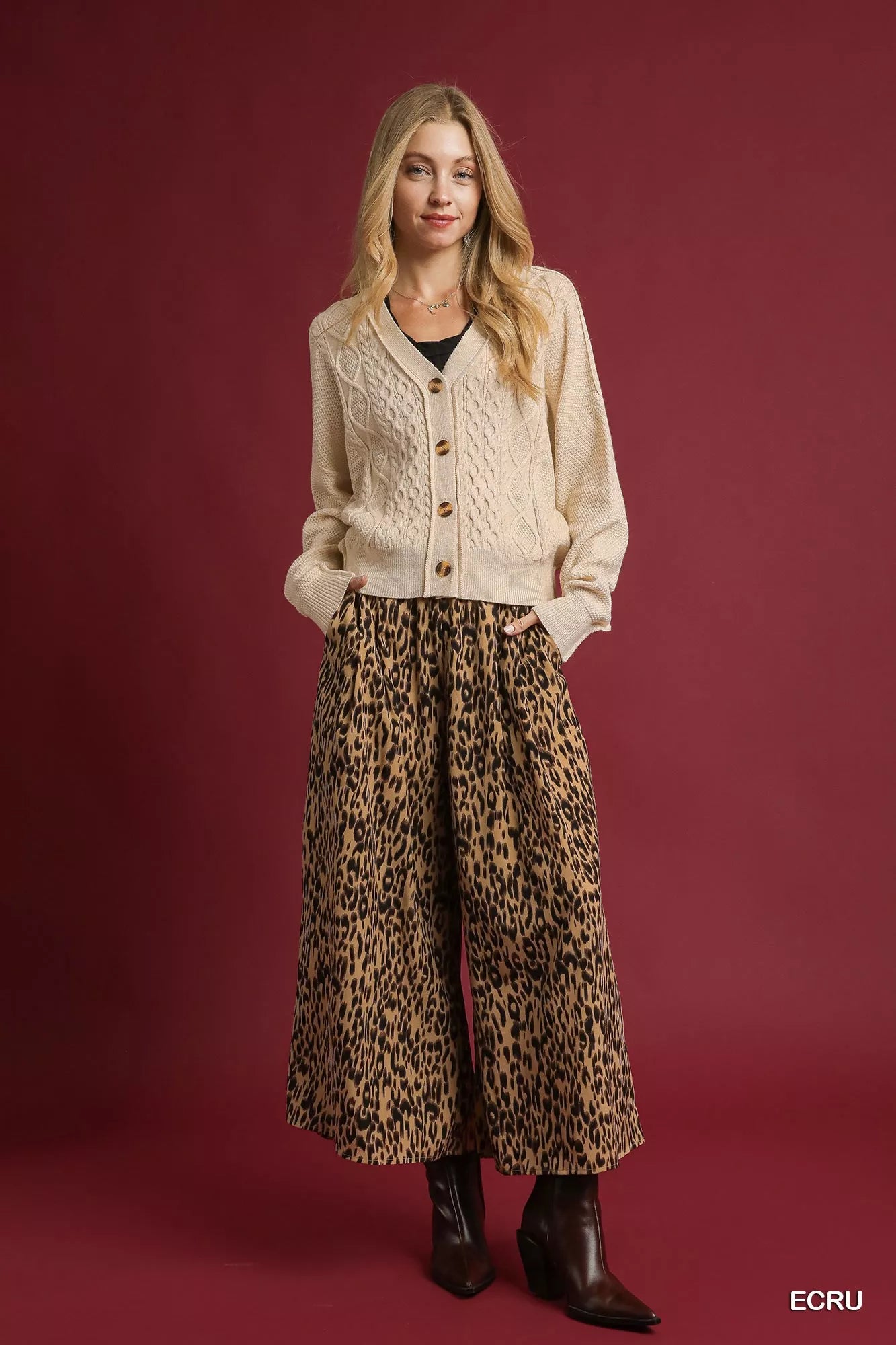 Uma Button-Up Cable Knit Cardigan – cropped silhouette in ecru, styled over pants.