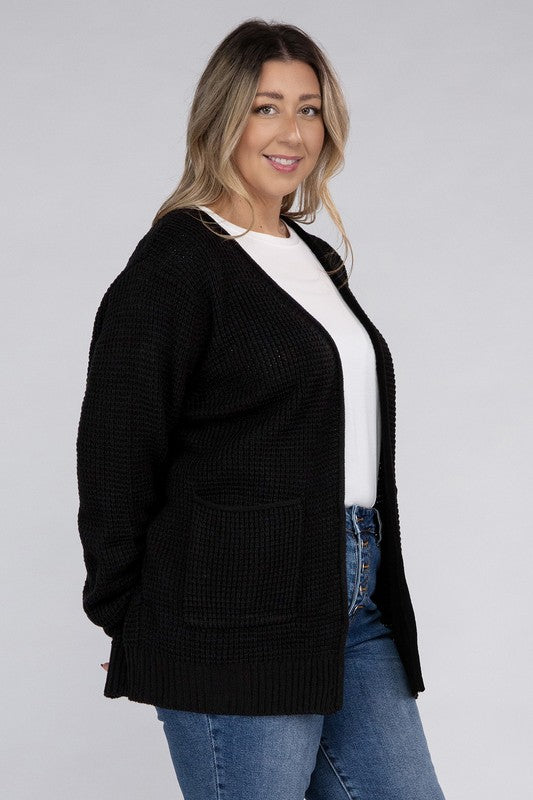 Curvy plus-size waffle-pattern open cardigan sweater in black, with long sleeves, oversized fit, and pockets.