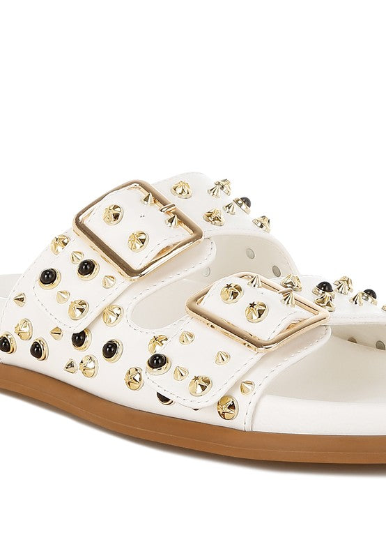 Jayata white faux leather slip-on sandals with metallic studs and cushioned comfort sole.