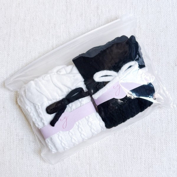 Packaged set of black and white Yarn Bow Socks with yarn bow detail.