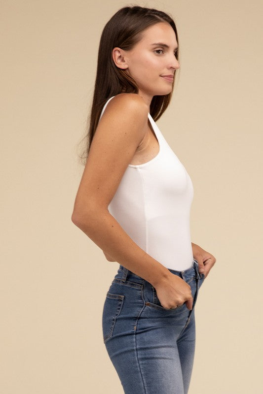 Sleeveless bodysuit in bone with a boat neckline, padded bodice, and removable bra pads for adjustable comfort.