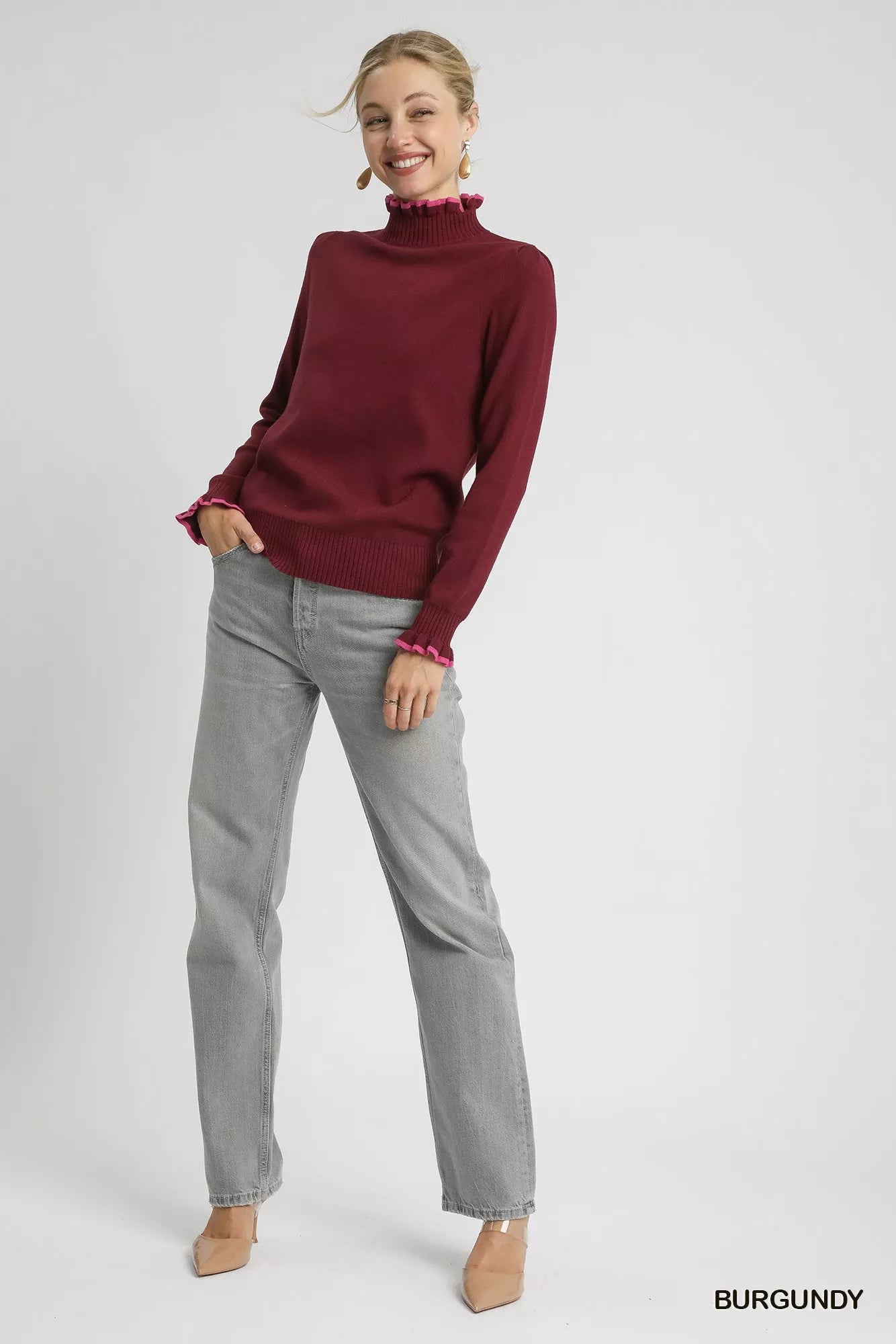 Plus front view: Burgundy ribbed sweater with pink ruffle trim, round neck.