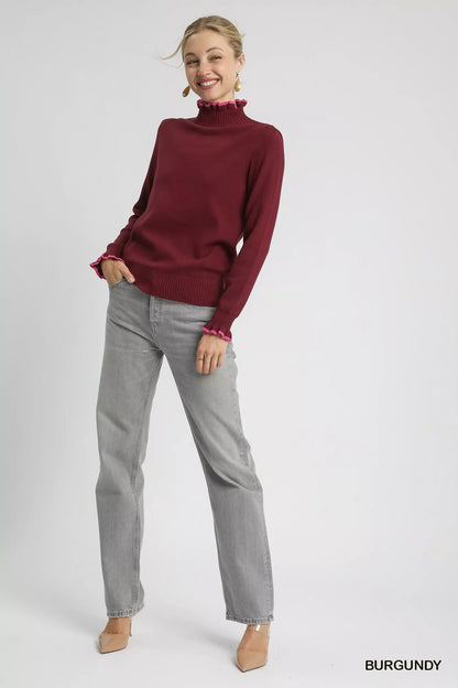 Plus front view: Burgundy ribbed sweater with pink ruffle trim, round neck.