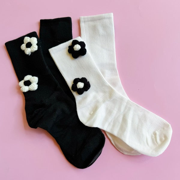 Flat lay of both black and white Puffy Daisy Socks displayed as a set.