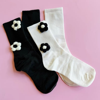 Flat lay of both black and white Puffy Daisy Socks displayed as a set.