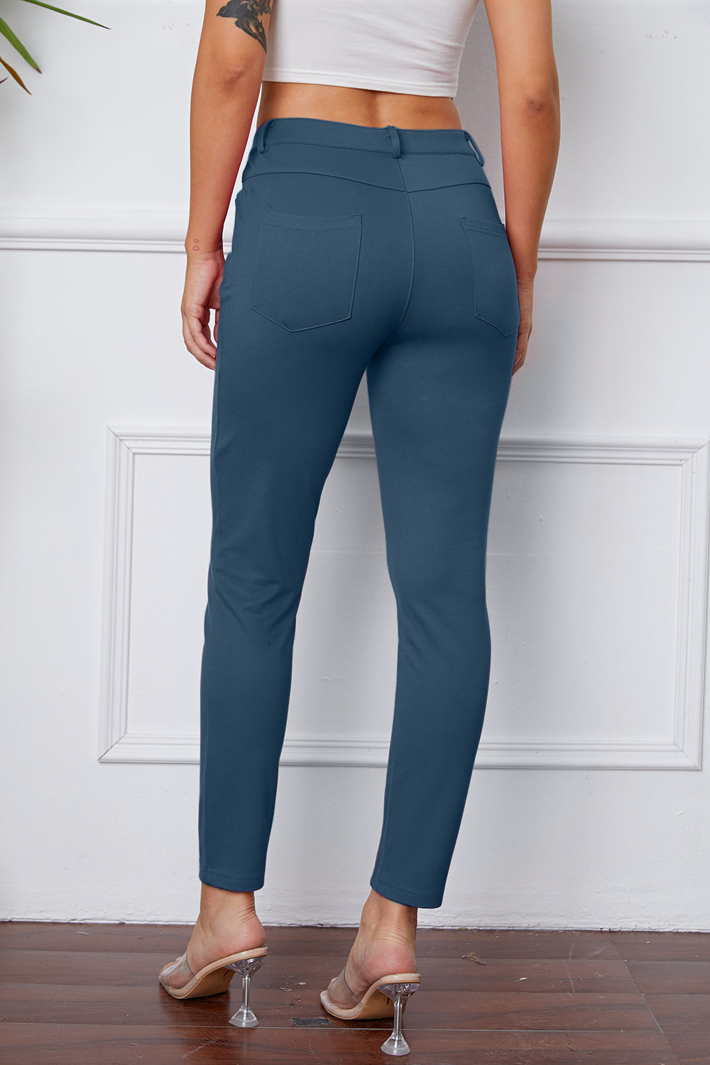 Dusty blue stretchy high-waisted pants feature pockets, a zip fly, and belt loops. 