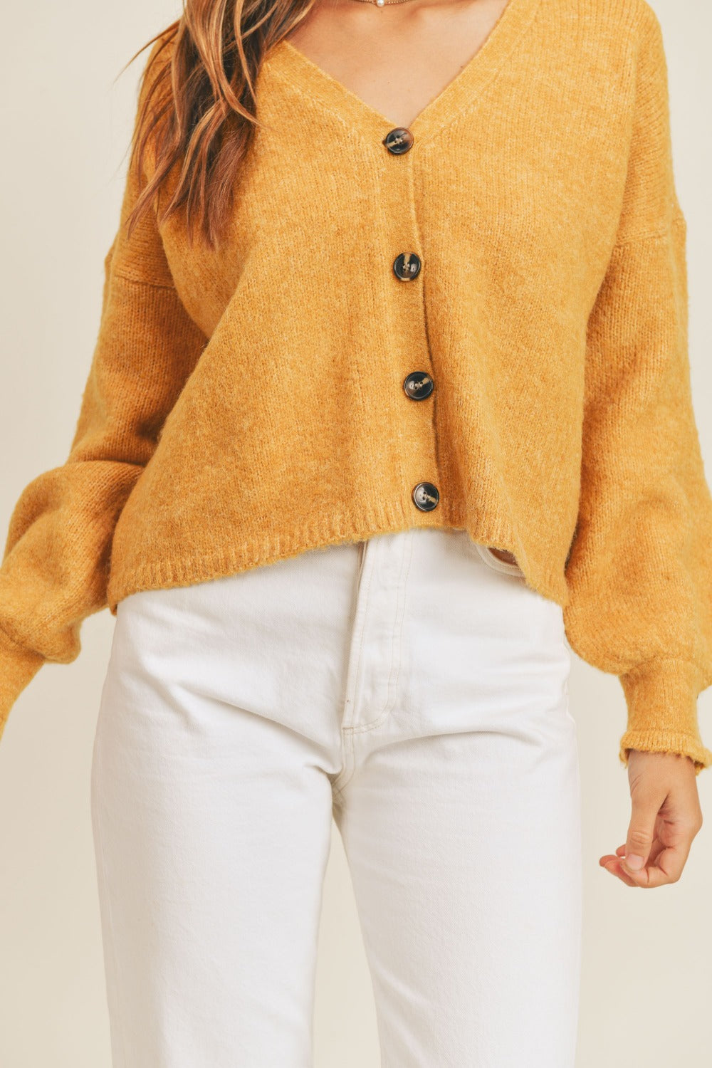 Women's mustard cardigan with a V-neckline, long sleeves, button-down closure, and a relaxed fit.