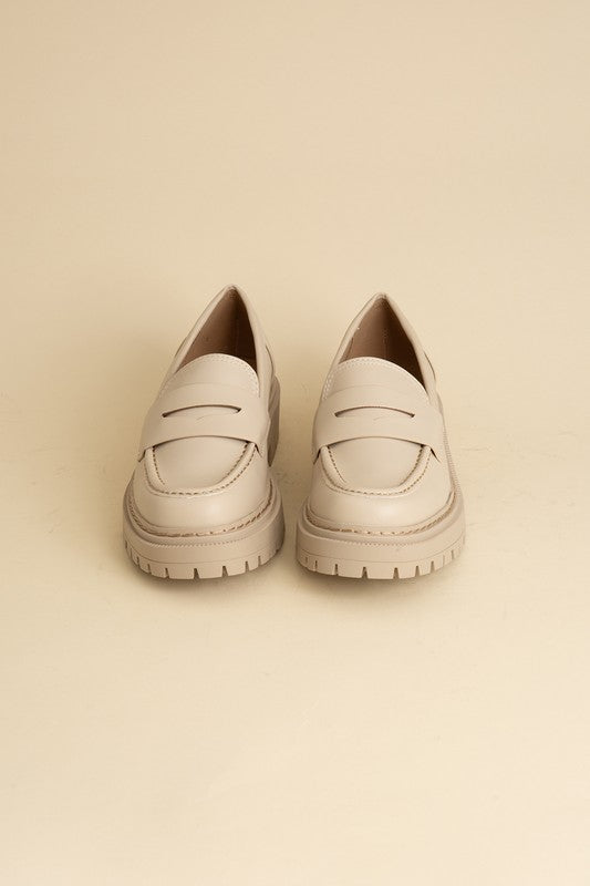 Bone classic loafers with a sleek design and minimalist accents.