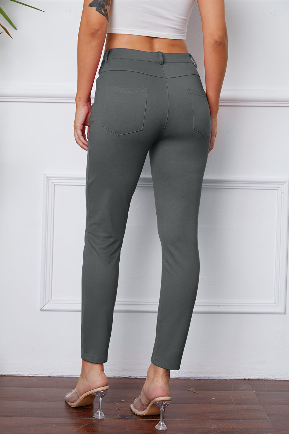 Gray stretchy high-waisted pants feature pockets, a zip fly, and belt loops. 