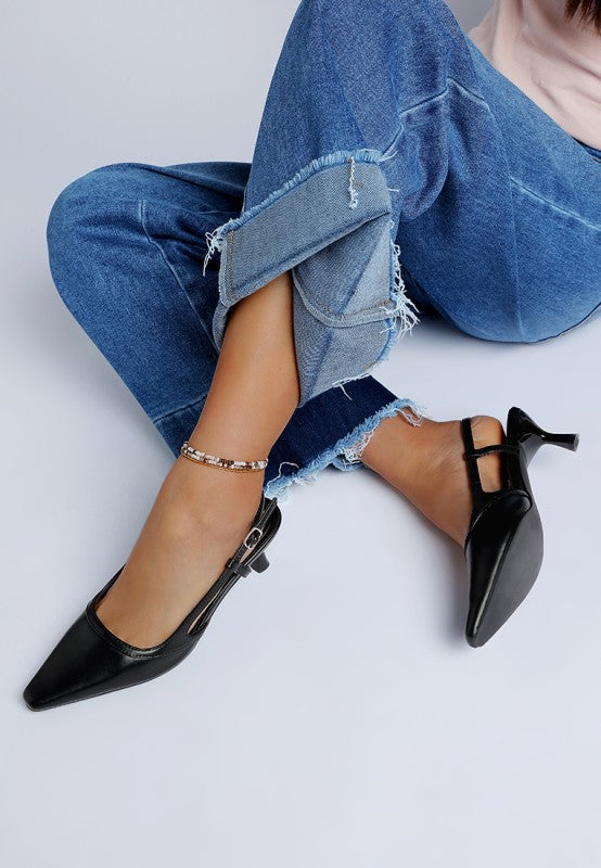 Model seated wearing Luxton Slingback Pin Buckle Kitten Heels in Black with cuffed jeans