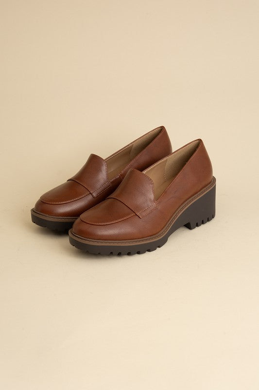 Chunky loafers in cognac feature a sleek design with a 2.3" heel.