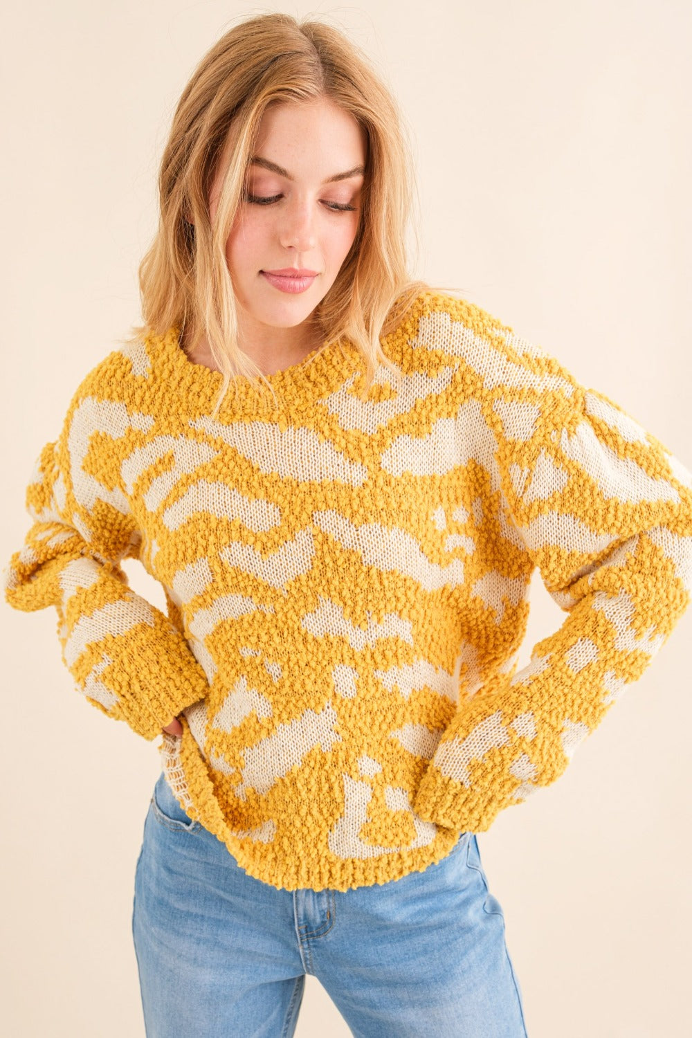 Women's textured mustard sweater with a round neckline and long sleeves.