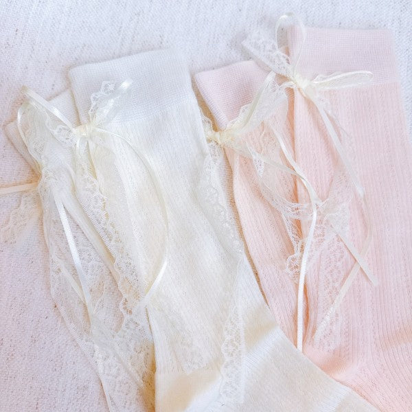 Flat lay of white and pink Lace & Satin Bow Back Socks with lace trim and satin bows.