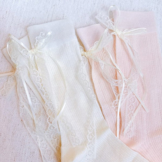 Flat lay of white and pink Lace & Satin Bow Back Socks with lace trim and satin bows.