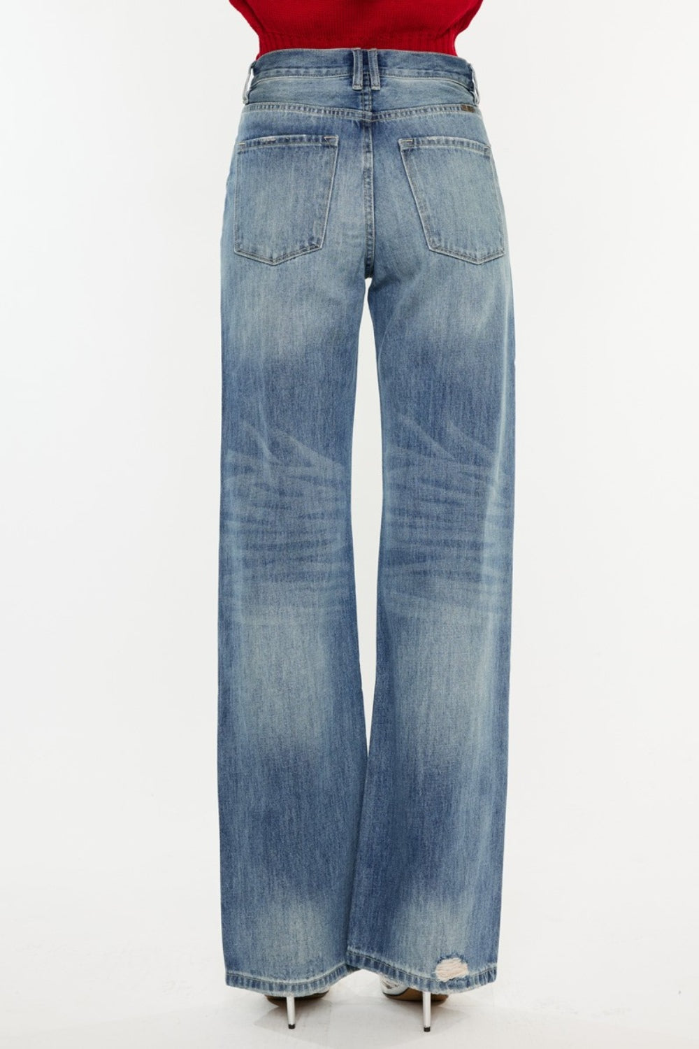 Distressed high-rise bootcut jeans with pockets and a slightly stretchy, washed fabric, offering a retro-chic style.