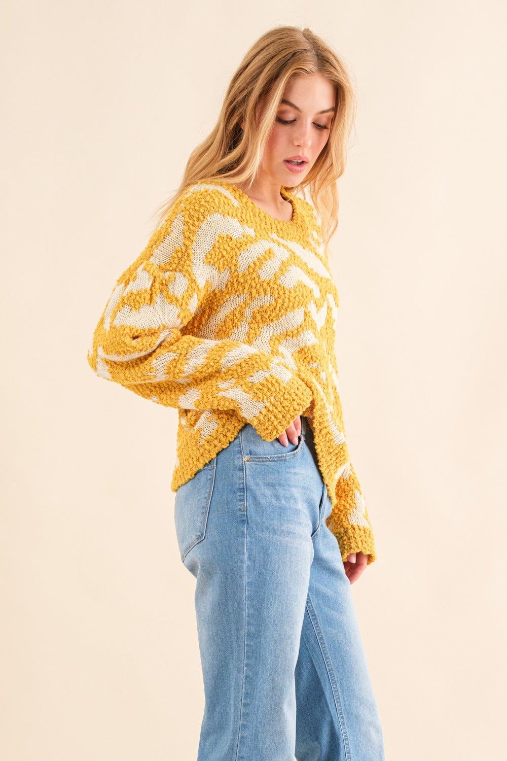 Women's textured mustard sweater with a round neckline and long sleeves.