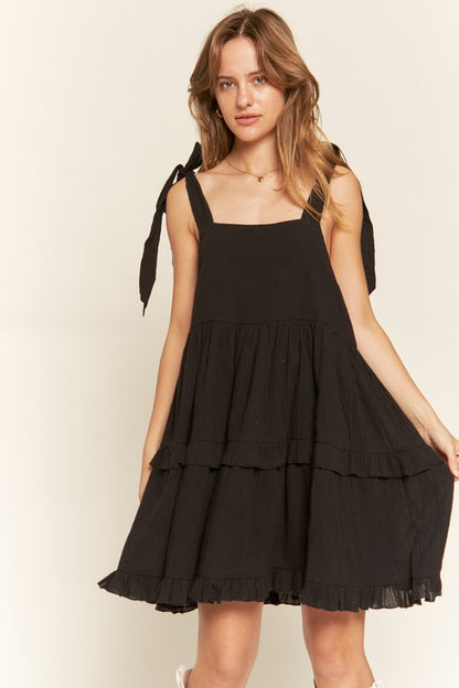 Front view of Edwina Plus Size Square Neck Ruffle Dress in black with self-tie straps.