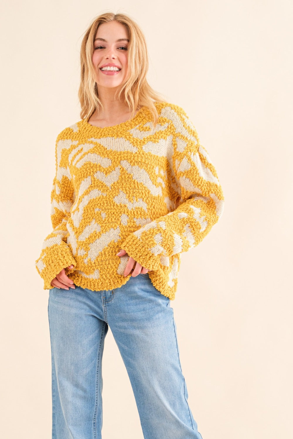 Women's textured mustard sweater with a round neckline and long sleeves.