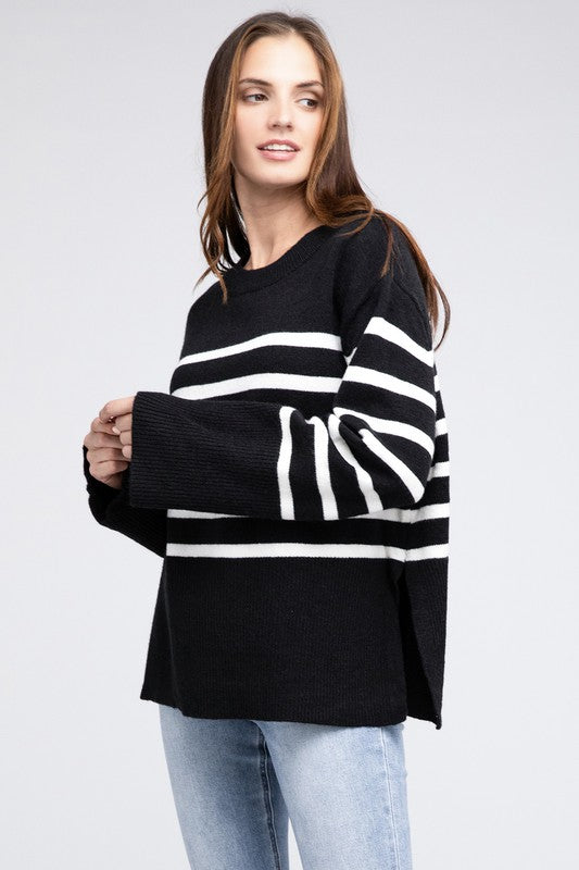 Black oversized sweater with a ribbed hem and striped pattern, featuring a round neckline and long sleeves.