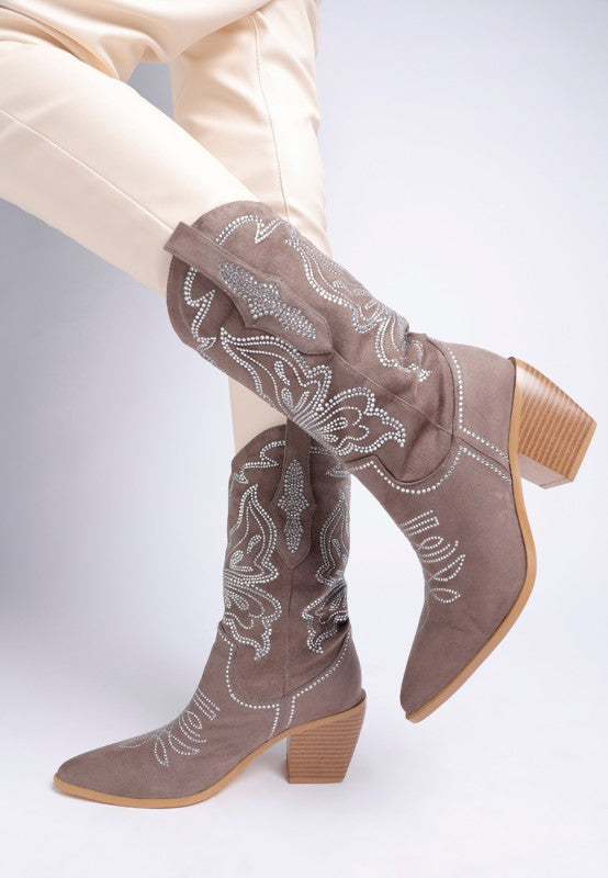Model wearing taupe rhinestone cowboy boots styled with cream pants