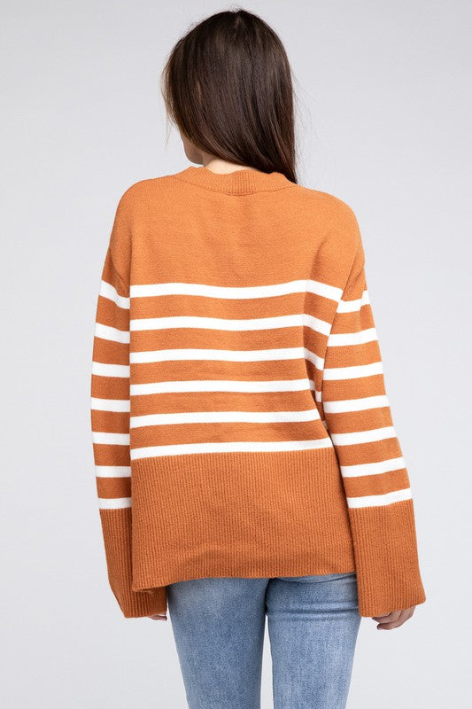 Rust oversized sweater with a ribbed hem and striped pattern, featuring a round neckline and long sleeves.