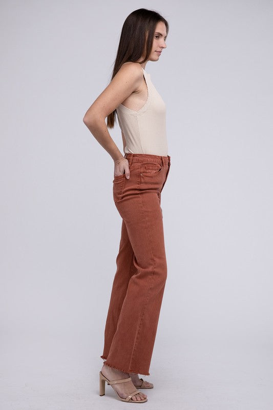 Rust acid-washed straight wide-leg pants featuring a frayed cutoff hem, zip fly closure, and a relaxed fit. Made with stretchy fabric for comfort and a unique vintage-inspired look.