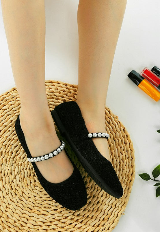 Top view of woman wearing both black Corphee Pearl Strapped Glitter Ballerinas, showing pearl strap and glitter finish.