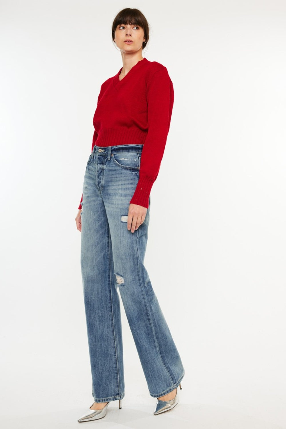 Distressed high-rise bootcut jeans with pockets and a slightly stretchy, washed fabric, offering a retro-chic style.