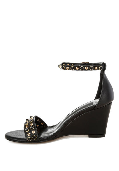 Medial side view black wedge sandals with studded ankle strap.