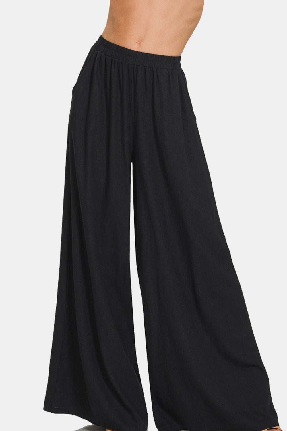 Black high-waisted pleated wide leg pants, elastic waist, made from a linen blend fabric.