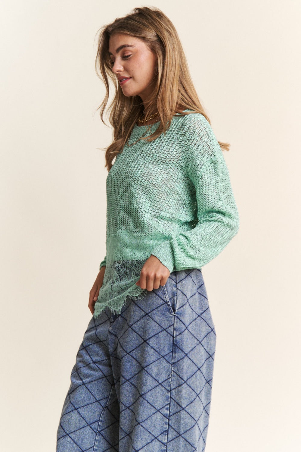 Women's sage sweater with lace detail, round neckline, long sleeves, and slightly stretchy fabric.