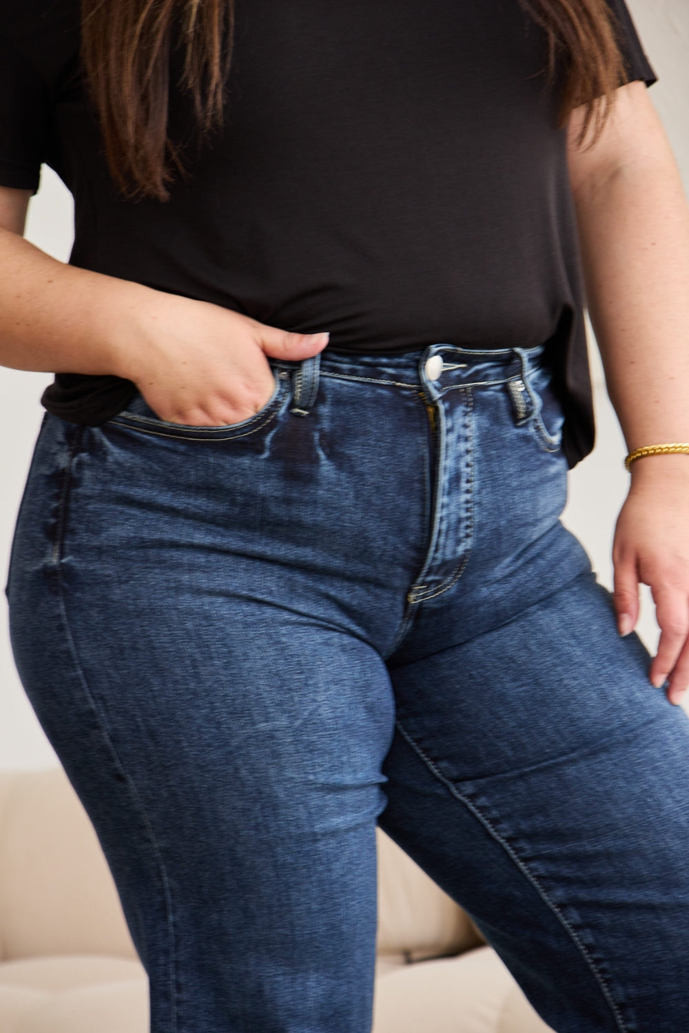 Dark wash high-waisted cropped jeans with tummy control, raw hem, and distressed details