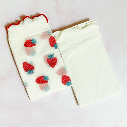 Folded strawberry and white dot sheer socks stacked to show playful designs.