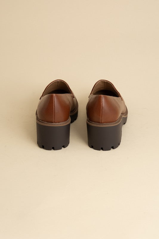 Chunky loafers in cognac feature a sleek design with a 2.3" heel.