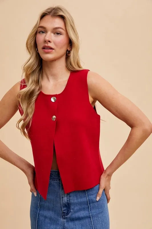 Chic red crop sweater vest featuring sleeveless design and stylish metal button accents for a polished look.